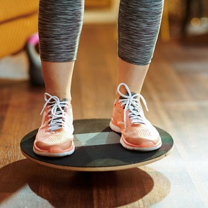 Closeup on fit sports woman while training using balance board