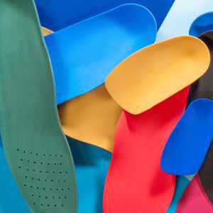 Assortment of different coloured and shapes of foot orthotics | FootWebStar Assortment of different coloured and shapes of foot orthotics